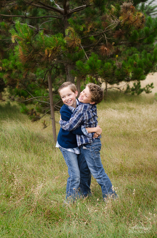 Two young brothers hugging in blue shirts, Pacific Grove portraits