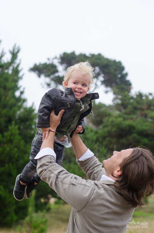 Father lifting baby boy in the air wearing black leather jacket