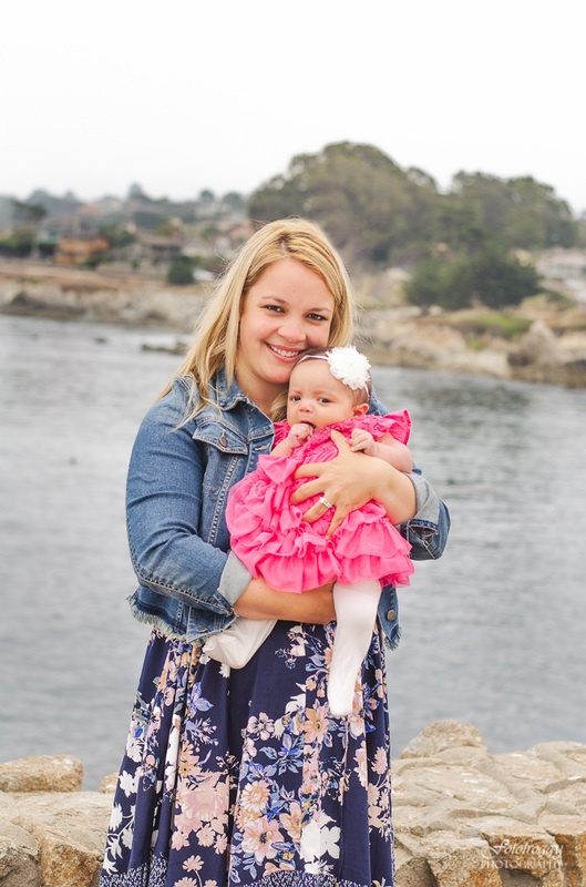 Cute mother-daughter portrait baby girl in pink ruffles by ocean Monterey Bay Ca