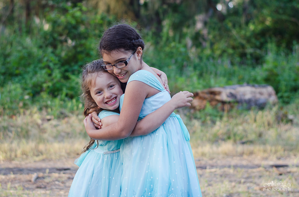 Sister hugging in blue dresses. Pacific Grove Family Portraits. www.fotofroggy.com